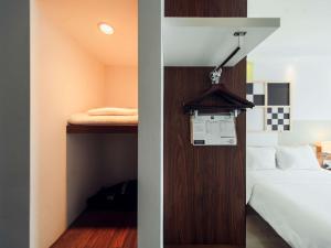 małą sypialnię z łóżkiem i szafą w obiekcie ibis Styles Warszawa Airport w Warszawie