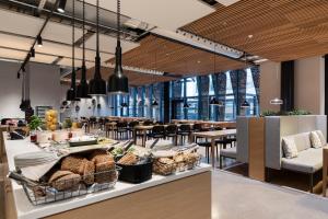 a restaurant with a counter with bread and tables at Heymo 1 by Sokos Hotels in Espoo
