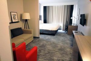 une chambre d'hôtel avec un lit et un canapé dans l'établissement Country Inn & Suites by Radisson, Council Bluffs, IA, à Council Bluffs