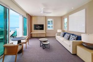 a living room with a couch and tables and windows at Wyndham Grand Barbados Sam Lords Castle All Inclusive Resort in Saint Philip