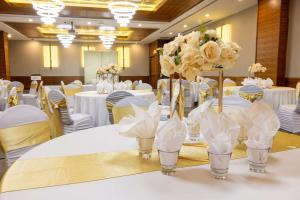 カルガリーにあるラディソン ホテル＆カンファレンスセンター カルガリー エアポート イーストの花瓶の白い花を飾ったテーブル付宴会場