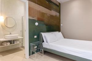 a bedroom with a bed with a sink and a mirror at Palazzo Albergamo in Favara +65 photos