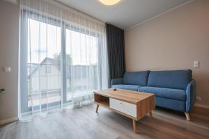 a living room with a blue couch and a table at Windway Apartments in Otepää