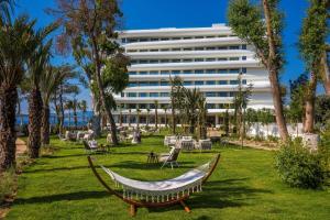 a hammock in a park in front of a hotel at Isla Brown Corinthia Resort & Spa, Curio Collection by Hilton in Agioi Theodoroi