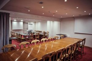 Hostellerie de la Tour d'Auxois في ساليو: قاعة اجتماعات كبيرة مع طاولة وكراسي طويلة