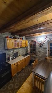 una cucina con armadi in legno e tavolo in legno di Vikendica Kapetan Bajski a Bezdan