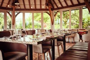 Hostellerie de la Tour d'Auxois في ساليو: غرفة طعام مع طاولة طويلة مع كؤوس للنبيذ