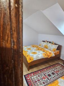 1 dormitorio con cama y alfombra en Casa Hera en Călimăneşti
