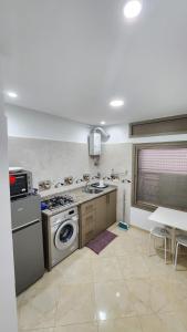 una cocina con estufa y lavadora en Appartements climatisés JANYA HOLIDAYS, en Alhucemas