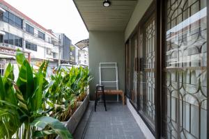 un balcón con plantas y una silla en un edificio en kasalong en Ban Song Krathiam