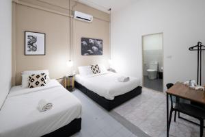 Habitación de hotel con 2 camas y escritorio en kasalong en Ban Song Krathiam