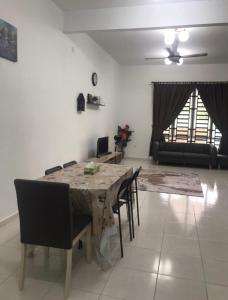 a dining table and chairs in a living room at De Lumpur Guest House in Kuantan