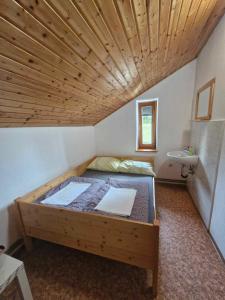 Cama grande en habitación con techo de madera en Črnuški dom na Mali planini en Krivčevo