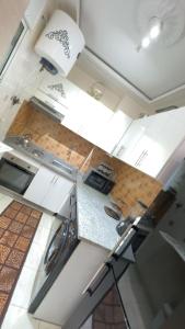 - une vue sur la cuisine avec des placards blancs dans l'établissement Well-furnished apartment i Agadir!, à Agadir