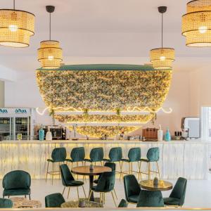duży żyrandol w restauracji z krzesłami i stołami w obiekcie Zoe Hotel, Trypiti Beach Resort & Hive water park w Limenárii