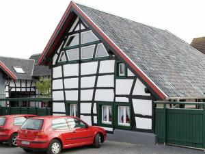 une maison avec une voiture rouge garée devant elle dans l'établissement Nostalgic apartment in the Eifel region, à Schleiden