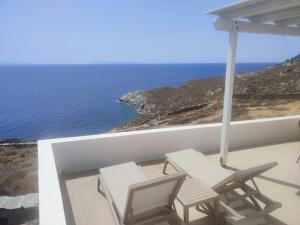 balcón con mesa, sillas y vistas al océano en Sifnos "Sofia apartments" sea view, en Faros