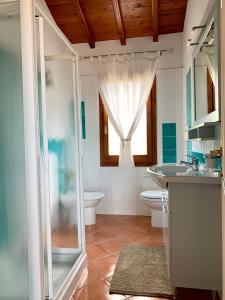 Un baño con ducha, inodoro y lavabo. en Sognatori Guest House - 400 mt from the Poetto beach, en Quartu SantʼElena
