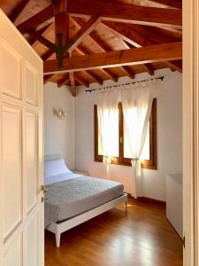 Un dormitorio con una cama y dos ventanas. en Sognatori Guest House - 400 mt from the Poetto beach, en Quartu SantʼElena