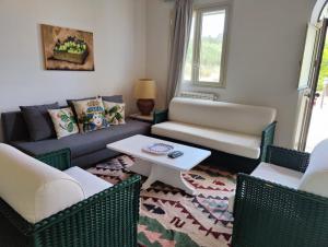 a living room with a couch and chairs and a table at Casa Titì in Cefalù
