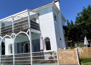 a white house with stairs and chairs in front of it at Villa face mer in Royan