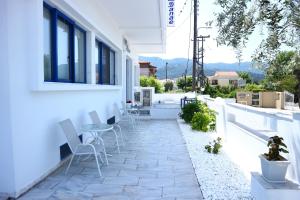 un patio avec des chaises et une table dans un bâtiment dans l'établissement Danae Hotel, à Thasos