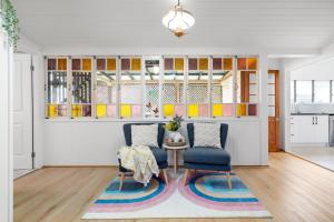 a living room with two chairs and a table at Heritage 5BR Queenslander- Walk to CBD&South Bank, 3 Parking in Brisbane