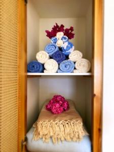 a shelf filled with towels and a pile of flowers at Villa Vivi in Finikas