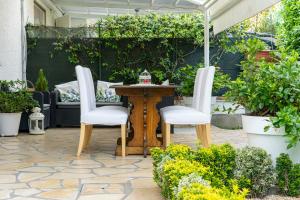 un patio con mesa, 2 sillas y sombrilla en Villino Claudia en Forte dei Marmi