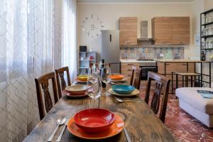 una mesa de madera con platos y gafas en la cocina en Villino Claudia, en Forte dei Marmi
