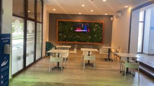 a restaurant with tables and chairs and a painting on the wall at ASTORIA Patria in Mamaia