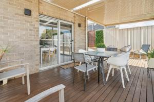 a patio with a table and chairs on a deck at Enfield Executive in Gepps Cross
