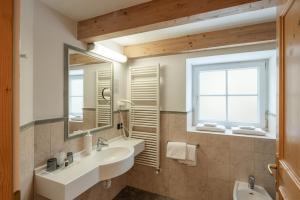 ein Badezimmer mit 2 Waschbecken und einem Spiegel in der Unterkunft Hotel Bellavista in Cavalese