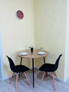 1 mesa y 2 sillas en una habitación en 1-комнатная комфортная кухня-студия со всеми удобствами en Kostanái