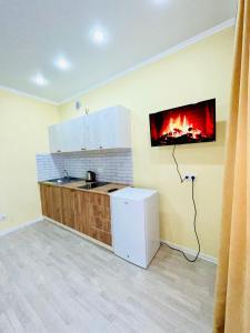 a kitchen with a fire hanging on the wall at 1-комнатная комфортная кухня-студия со всеми удобствами in Kostanay