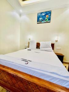 - une chambre avec un grand lit à publicité dans l'établissement Dodoma Star Lounge, à Dodoma