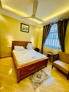- une chambre avec un lit, une chaise et une fenêtre dans l'établissement Dodoma Star Lounge, à Dodoma