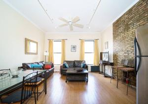 - un salon avec un canapé et un mur en briques dans l'établissement Lovely 1 BR Apartment in Manhattan, à New York