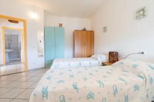 a bedroom with two beds and a blue cabinet at Casa Rockefeller in San Teodoro