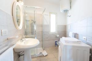 a white bathroom with a sink and a shower at Casa Rockefeller in San Teodoro