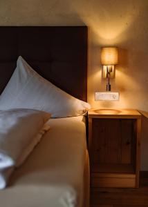 Appartements Gladbach في هايترفانغ: غرفة نوم بسرير مع مصباح على الموقف الليلي