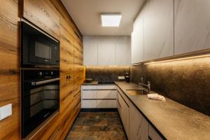 Appartements Gladbach في هايترفانغ: مطبخ مع دواليب بيضاء وتلفزيون على الحائط