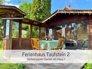 a screened in porch with a table and chairs at Kindertraum - Spielplatz - Spielzimmer - Terrasse mit Grill - Garten - wandern - 3 Schlafzimmer bis 9 Personen - Ferienhaus Taufstein 2 in Herbstein