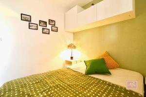 1 dormitorio con 1 cama con sábanas verdes y blancas en L’alyzarine, en La Seyne-sur-Mer