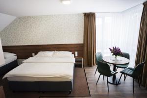 a hotel room with a bed and a table at Apartmány Banff in Bešeňová