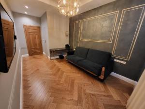 sala de estar con sofá negro y mesa en Uroczy loft i bezpłatny parking na miejscu en Lublin