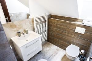 a bathroom with a white sink and a toilet at Apartmány Banff in Bešeňová