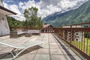a patio with a white chair on a balcony with mountains at Gaillands North in Chamonix