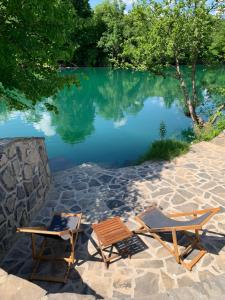 two lounge chairs and a pool of water at Kuća za odmor KRNJAIĆ,porodični KAMP in Bosanski Novi