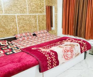 a large bed with a pink blanket on it at Hotel Hari Krishnashrya in Vrindāvan